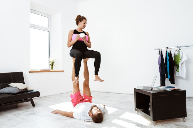 Молодые красивые спортивные пары обучения йоги асаны дома.