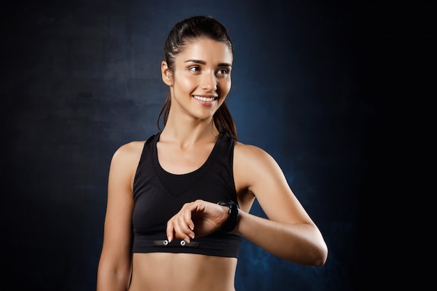  young beautiful sportive girl posing over dark wall.