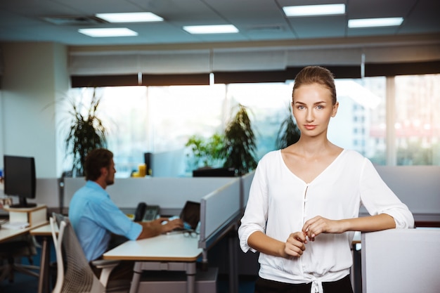 Young beautiful successful businesswoman smiling, posing, over office