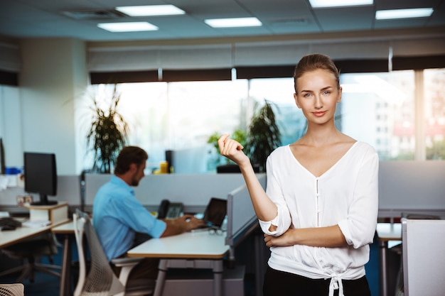 Young beautiful successful businesswoman smiling, posing, over office