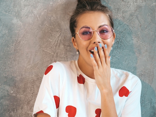 Foto gratuita la giovane bella donna sorpresa che osserva con le mani si avvicina alla bocca. ragazza alla moda in abito bianco estivo casual.