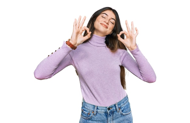 Free photo young beautiful teen girl wearing turtleneck sweater relaxed and smiling with eyes closed doing meditation gesture with fingers. yoga concept.
