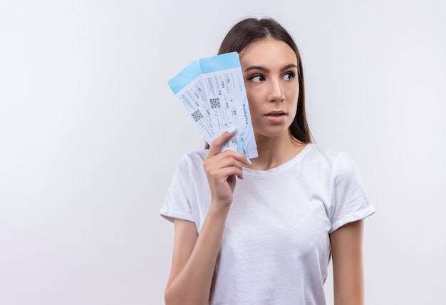 Young beautiful traveler girl holding air tickets looking aside confused and very anxious 