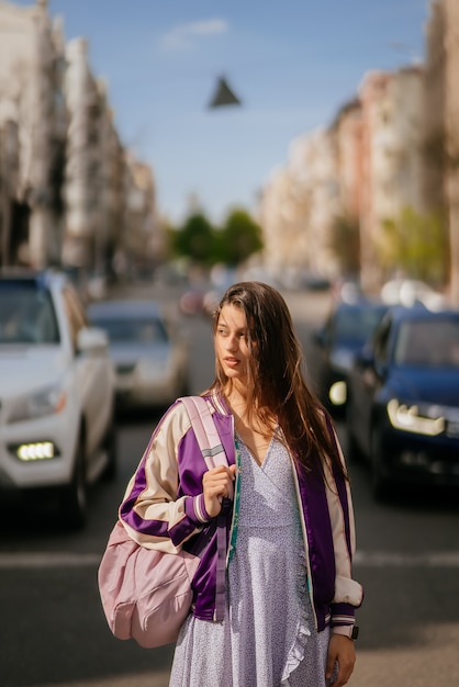 Young beautiful woman on the background of cars