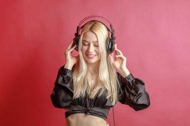 Free photo young beautiful woman in bright outfit enjoying the music at home