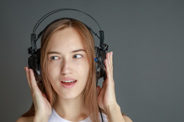 Young beautiful woman in bright outfit enjoying the music at home