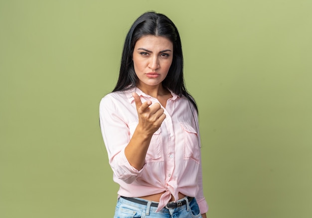 Giovane bella donna in abiti casual che guarda con la faccia seria dispiaciuta