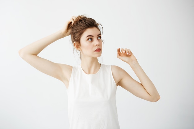 Young beautiful woman correcting hair bun