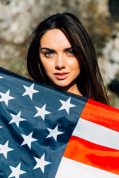 Foto gratuita giovane bella donna ricoperta di bandiera americana