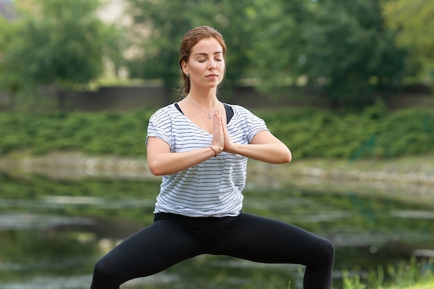 Free photo young beautiful woman doing yoga exercise in green park
