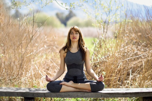 Young beautiful woman doing yoga in nature