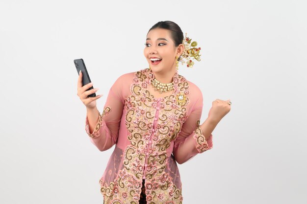 Young beautiful woman dress up in local culture in southern region pose with smartphone