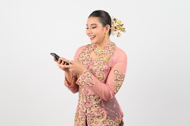 Young beautiful woman dress up in local culture in southern region pose with smartphone