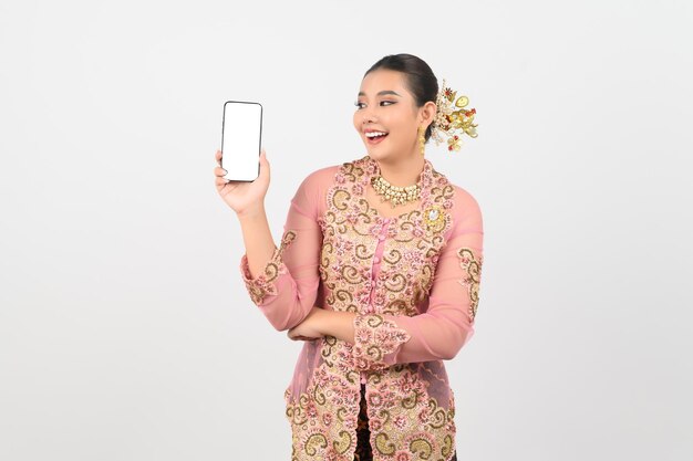 Молодая красивая женщина в одежде местной культуры в южном регионе позирует со смартфоном