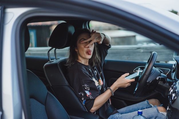 若くてきれいな女性が車を運転します。肖像画のクローズアップ