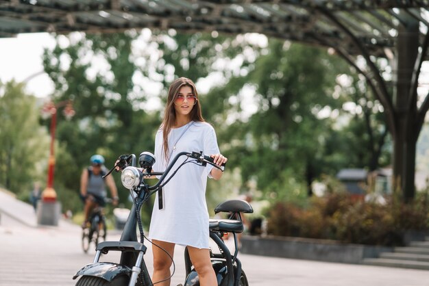 Young beautiful woman and an electric scooter