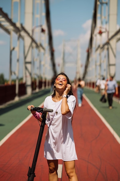 Free photo young beautiful woman and an electric scooter