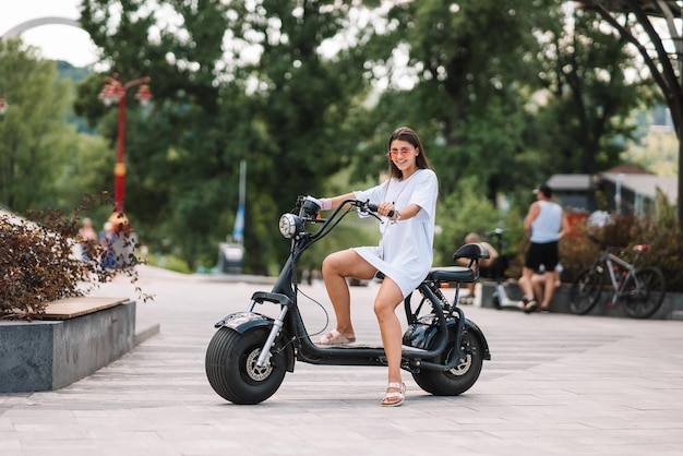 Giovane bella donna e uno scooter elettrico