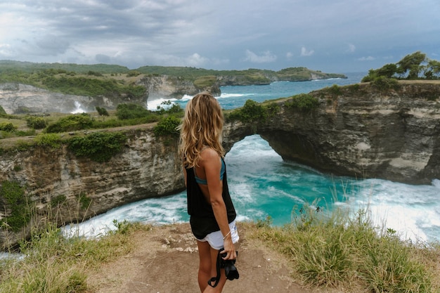 Young beautiful woman filming on camera while traveling