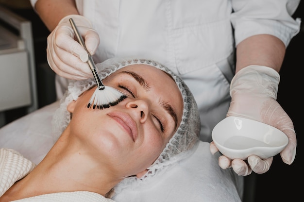 Young beautiful woman getting a face skin treatment at the wellness center