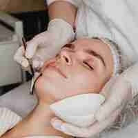 Free photo young beautiful woman getting a face skin treatment