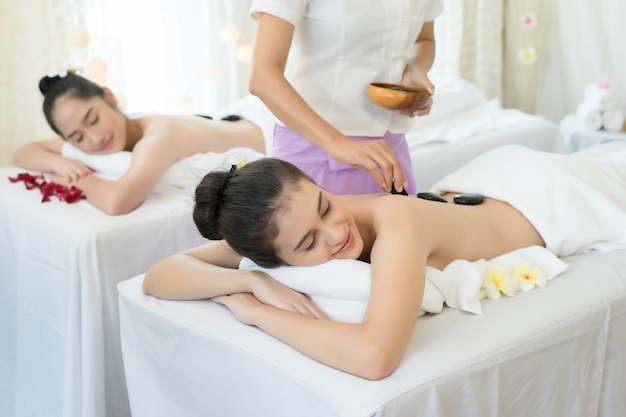 Young beautiful woman getting hot stone spa treatment.