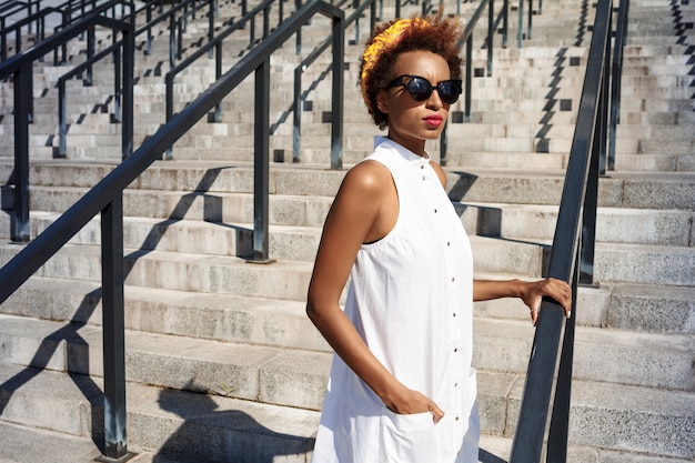 Young beautiful woman going up stairs walking down city