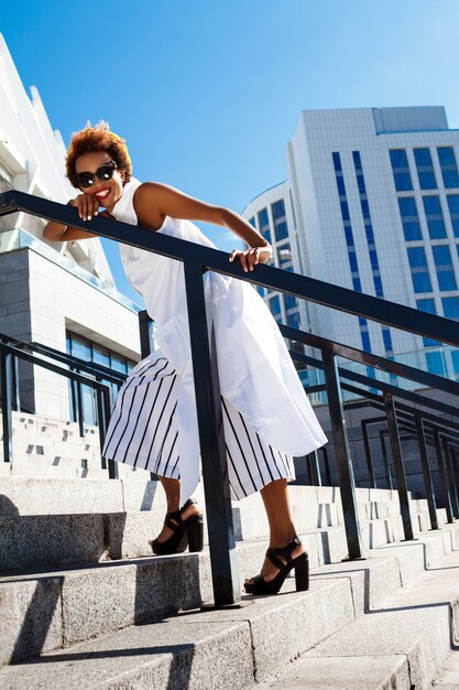 Young beautiful woman going up stairs walking down city