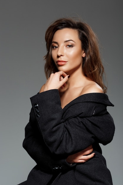 Young beautiful woman  over grey wall