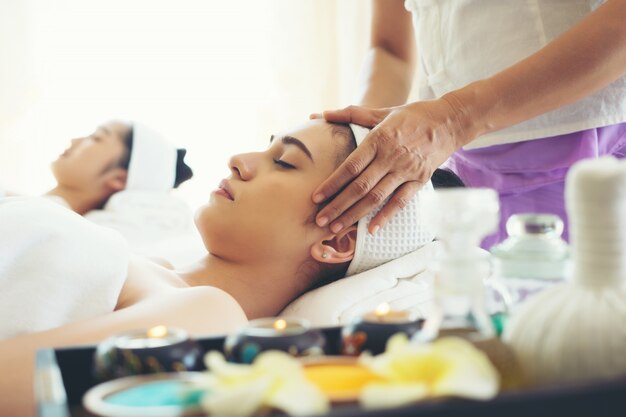 Young beautiful woman having face massage relaxing in spa.