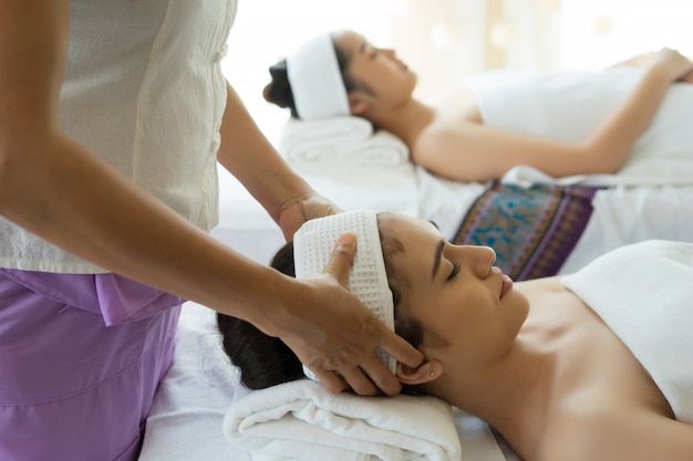 Free photo young beautiful woman having face massage relaxing in spa.