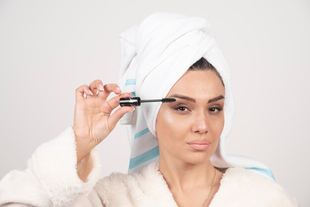 Young beautiful woman holding a black mascara .