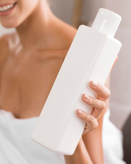 Free photo young beautiful woman holding a bottle of body lotion