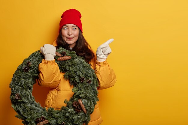 クリスマスの装飾を保持している若い美しい女性