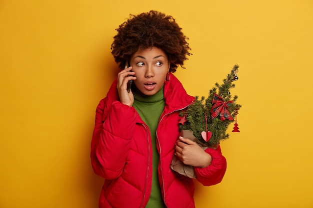 Giovane bella donna che tiene le decorazioni di natale