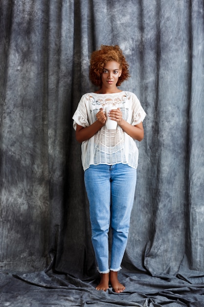 Young beautiful woman holding cup, posing