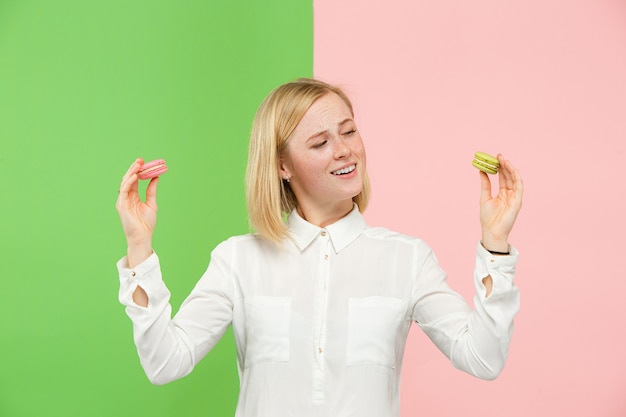 Free photo young beautiful woman holding macaroons pastry in her hands