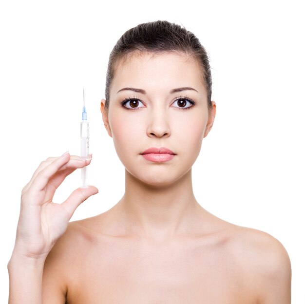 Young beautiful woman holding medical syringe in hand  