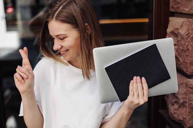 Young beautiful woman holding workbooks and smiling