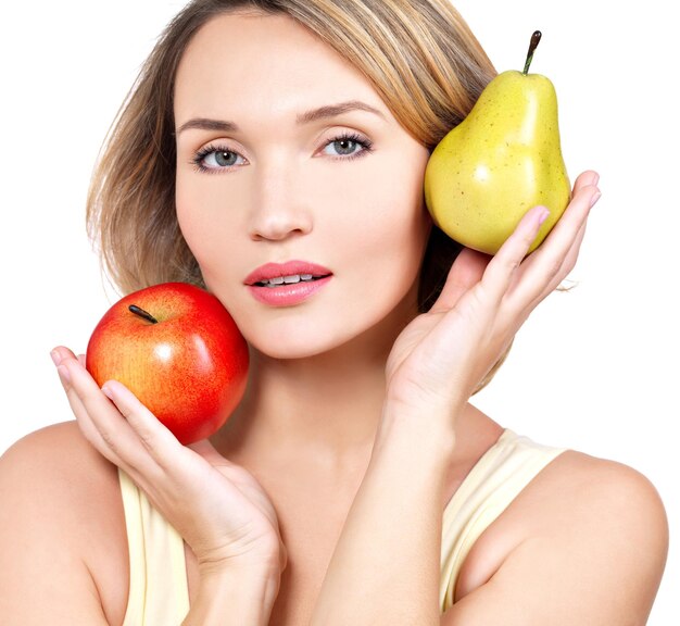 Young beautiful woman holds the apple and pear - isolated on white.