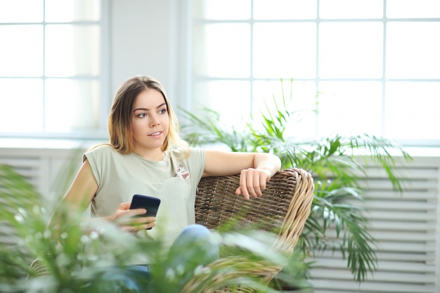 Young beautiful woman at home with plants