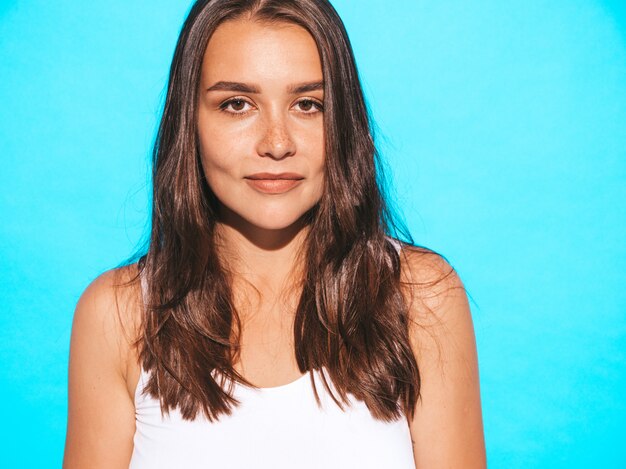 Young beautiful woman looking. Trendy girl in casual summer clothes. Funny and positive female posing near blue wall