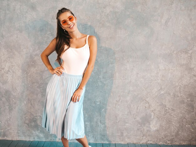 Young beautiful woman looking . Trendy girl in casual summer dress and sunglasses.  