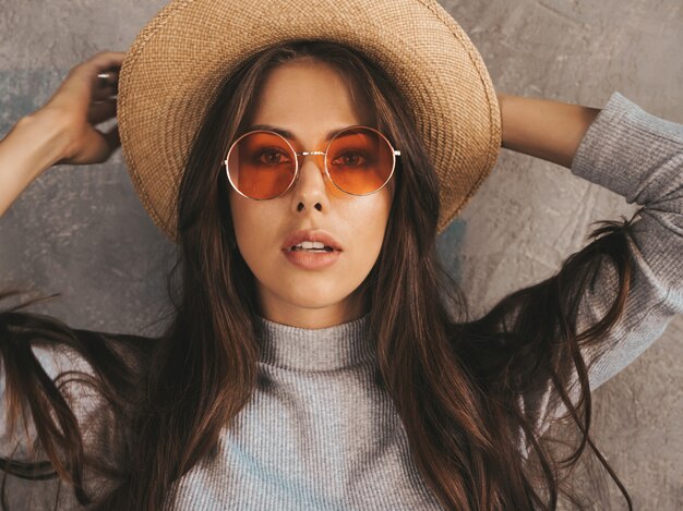 Young beautiful woman looking . Trendy girl in casual summer overalls clothes and hat. 