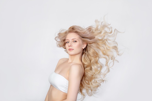 スタジオ​の​白い​背景​の​上に​ファッショナブル​で​スタイリッシュ​な​若い​美しい​女性​モデル