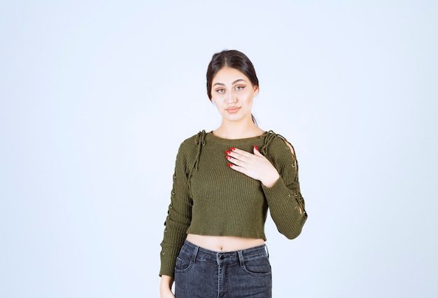 young beautiful woman model standing and posing over white wall.