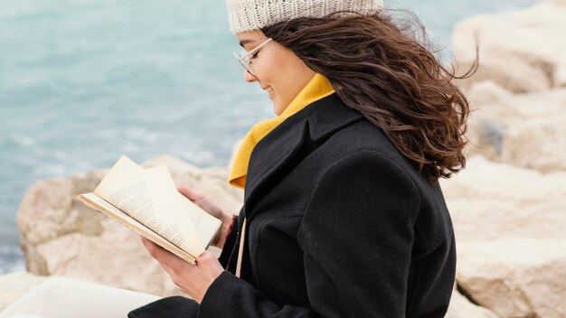 Young beautiful woman in nature reading book