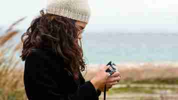 Free photo young beautiful woman in nature with camera