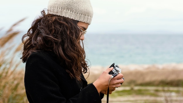 Young beautiful woman in nature with camera