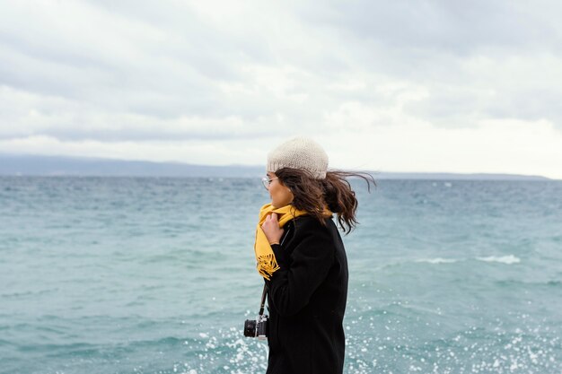 Young beautiful woman in nature with camera